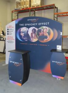 SYK-1010 Symphony Portable Display with SEG Tension Fabric Graphic, Backwall Workstaion Counters, Wireless Charging Pads, Direct Print Graphics, SYM-408 Counter with Locking Storage, and (2) LED Stem Lights